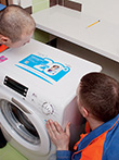 Строители компании АСК Ремрайон монтируют стиральную машину в ванной комнате